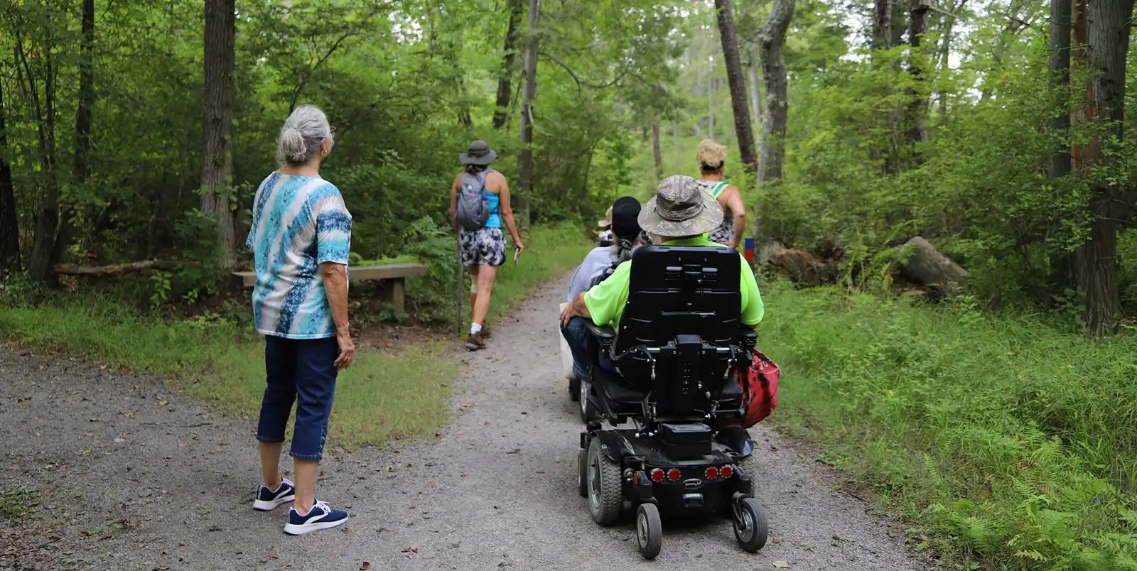 Hikers and participants in powered chairs exploring Atsion Recreation Area.