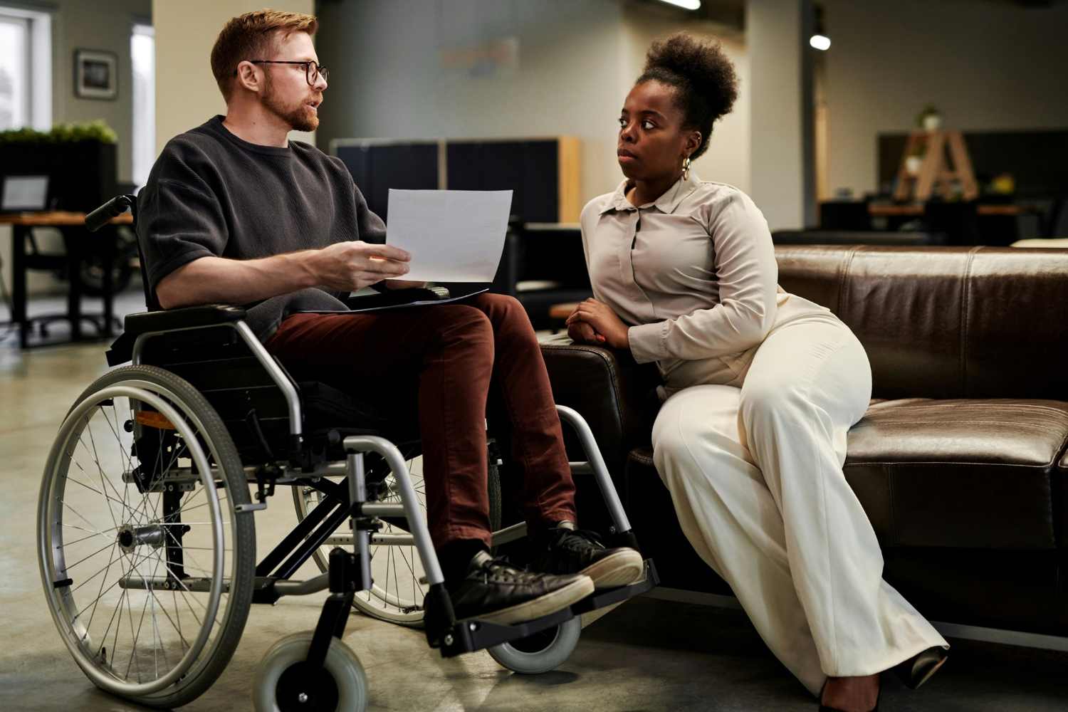 Two people having conversation, one in a wheelchair.
