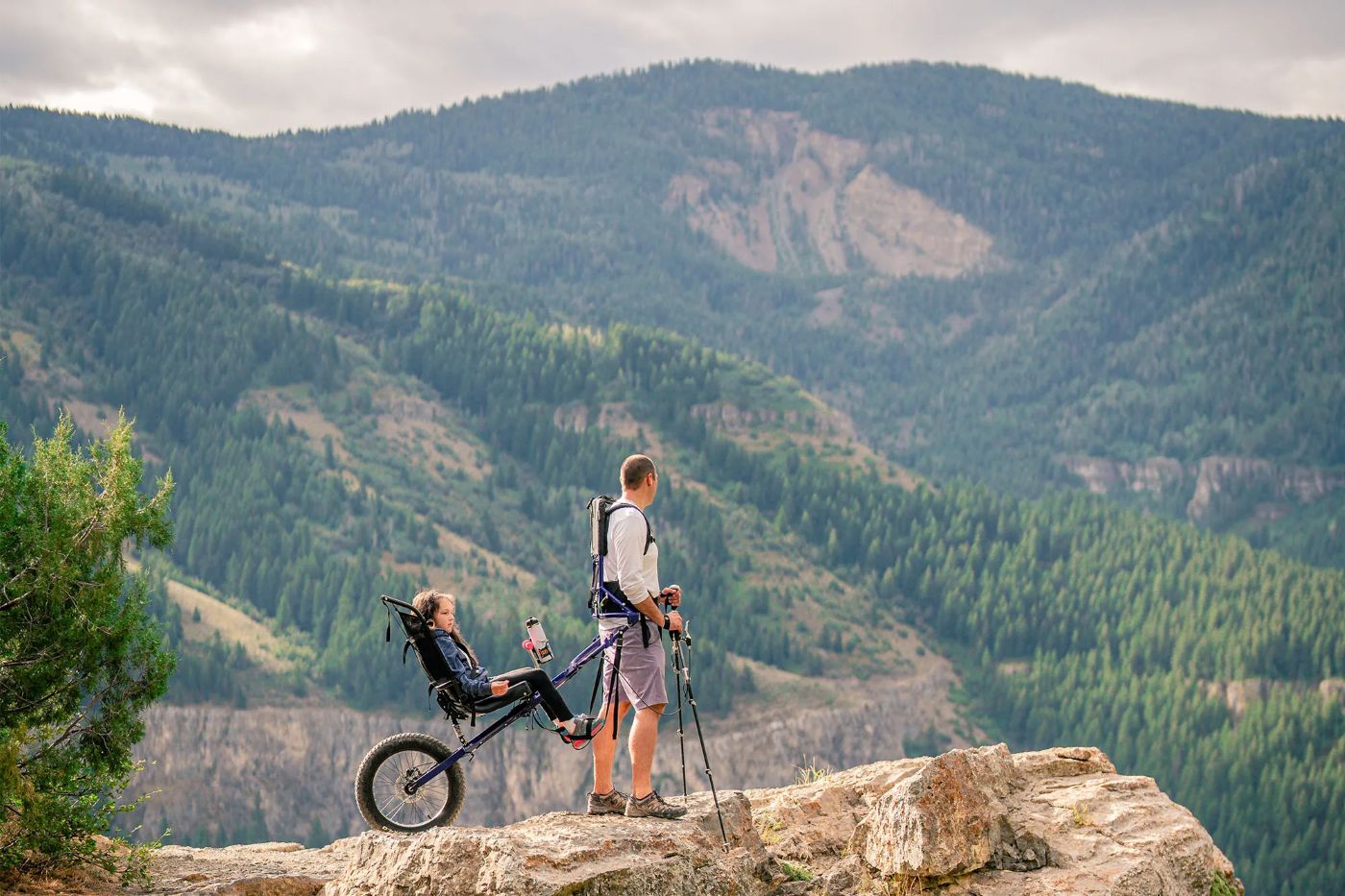 Man and daughter on nature trail with adaptive cart